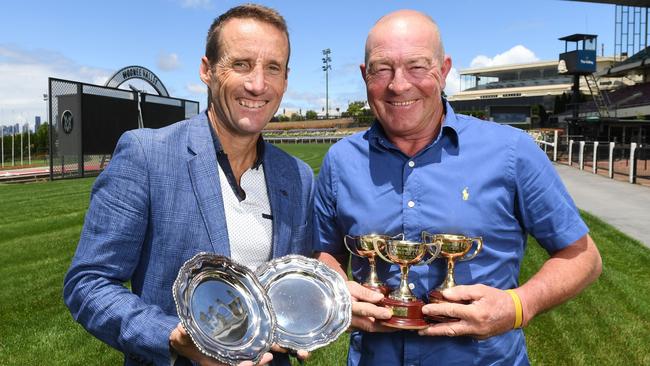 Retired champion Damien Oliver with his Cox Plate trophies while master driver Chris Alford shows off his Hunter Cup trophies. Picture: Josie Hayden