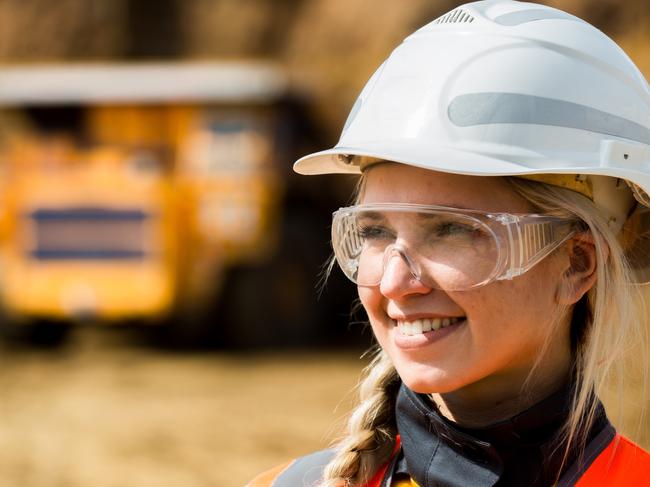 Mine worker with huge truck on the background in open pit. mining worker istock