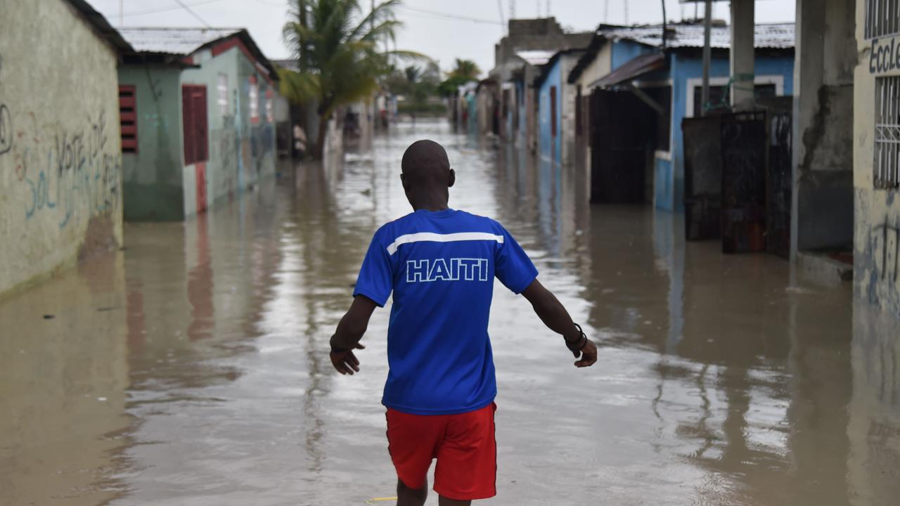 A man walks down a flooded street in Cite Soleil after Hurricane Matthew slammed into Haiti in 2016. Picture: AFP PHOTO / HECTOR RETAMAL