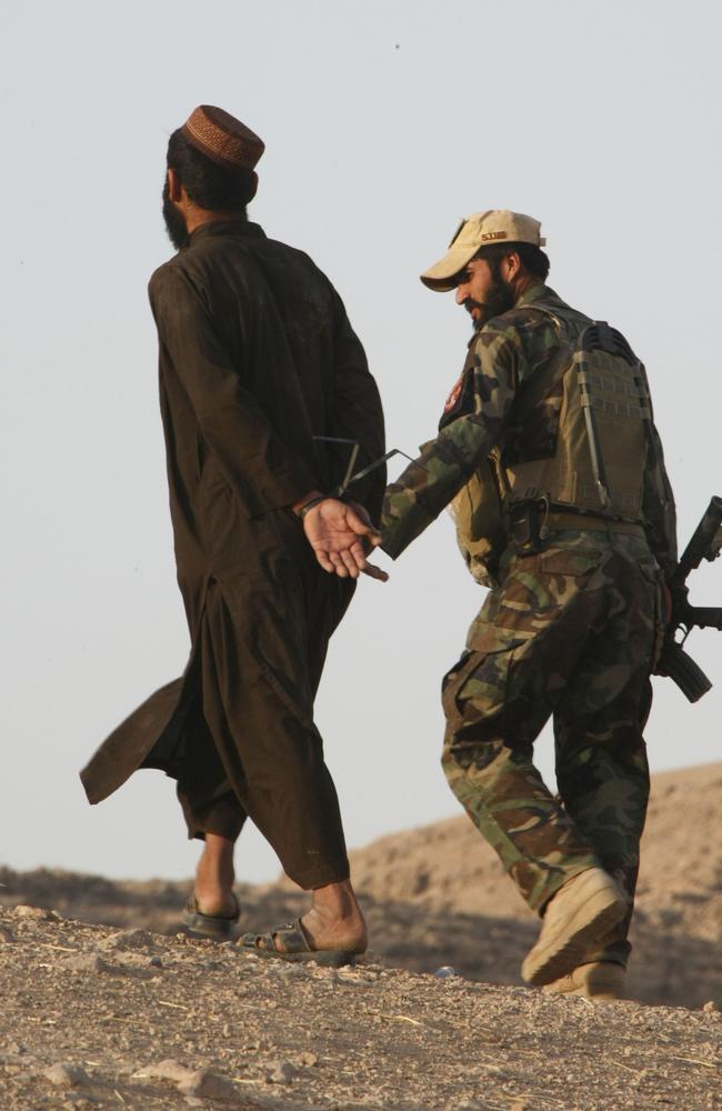 An Afghan National Army Special Forces Commando (ANASF), who was caught local Afghan men brought in for questioning during a recent partnered ANA and Australian operation to clear a township of Taliban fighters.