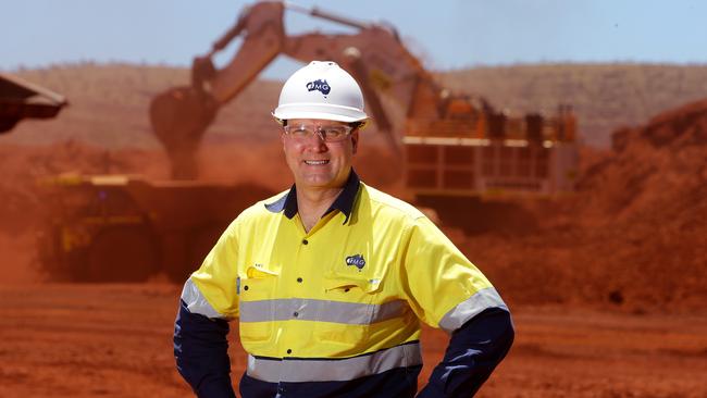 CEO of Fortescue Metals Group Ltd Nev Power at the new Kings Mine, Pilbarra. Loading of automated truck in background with iron ore.