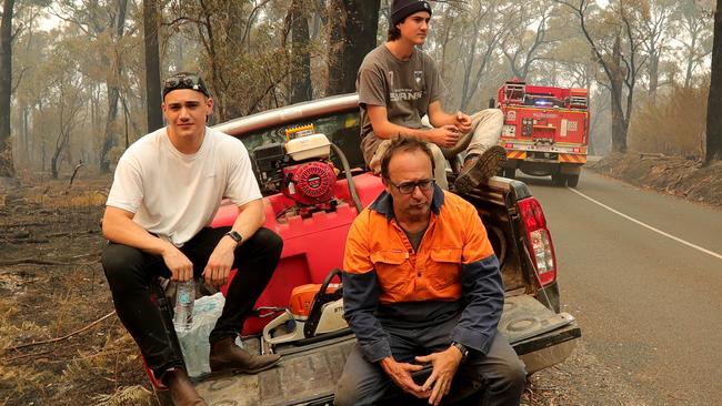 Mark Knight with his sons Jack &amp; Elliott, in Tonimbuk, managed to save their property after a bushfire engulfed the Bunyip state forest in Victoria.  Picture: Stuart McEvoy.