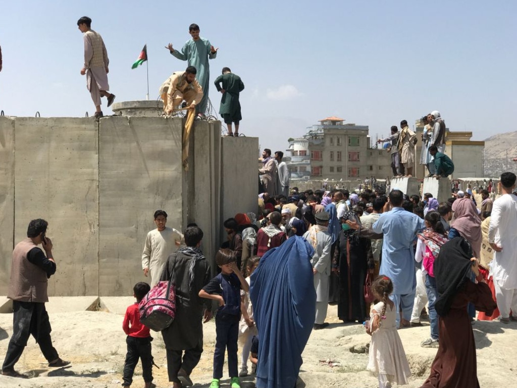 People climb the border of the airport in a desperate bid to flee. Picture: STR/NurPhoto via Getty Images