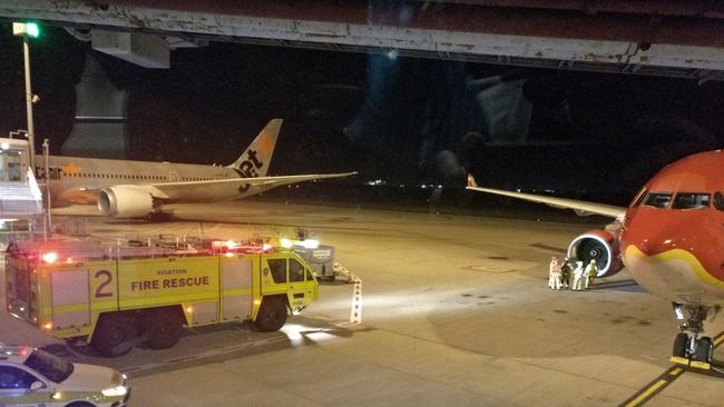 This picture taken by Calvin Boon on July 4, 2017 shows fire rescue personnel beside the starboard engine of an AirAsia Airbus A330, after the aircraft on flight D7207 made an emergency landing at the Brisbane International Airport. Photo: Calvin Boon