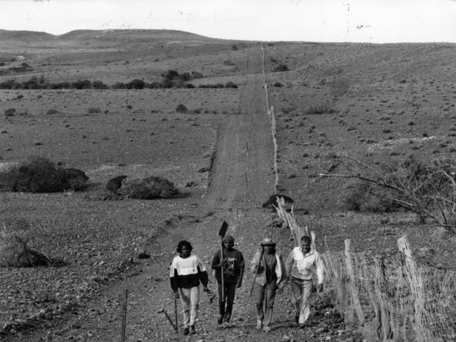Workers fix the dog fence near Coober Pedy in 1992.