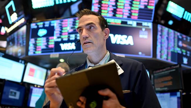 (FILES) In this file photo Traders work during the closing bell at the New York Stock Exchange (NYSE) on March 18, 2020 at Wall Street in New York City. - Wall Street stocks jumped early March 25, 2020 as markets awaited a vote on a $2 trillion package agreed by congressional leaders to boost the US economy ravaged by the coronavirus outbreak.About 15 minutes into trading, the Dow Jones Industrial Average was up 2.6 percent, or around 540 points, at 21,244.77. (Photo by Johannes EISELE / AFP)