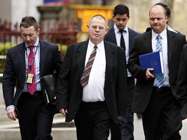 George Williams (centre) walks with police to the County Court during the murder trial of Carl.