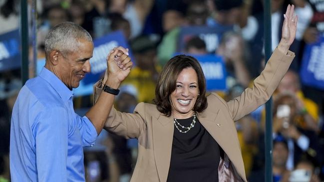 Barack Obama holds hands with Kamala Harris at her Georgia rally. Picture: AP.