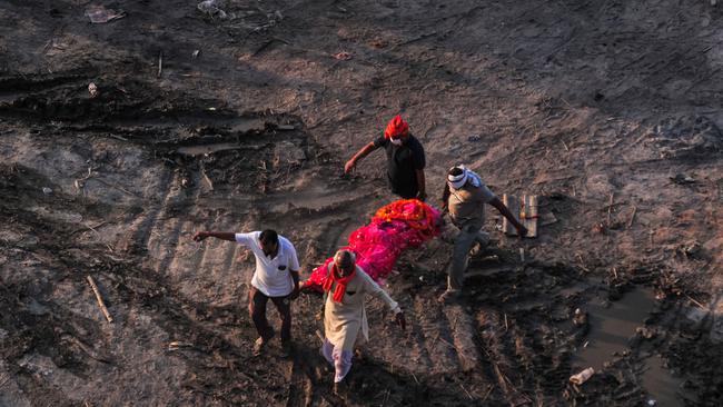 Relatives carry a body of a relative to a funeral pyre at a mass crematorium site on the banks of the Ganges river in Allahabad, India. Picture: Getty