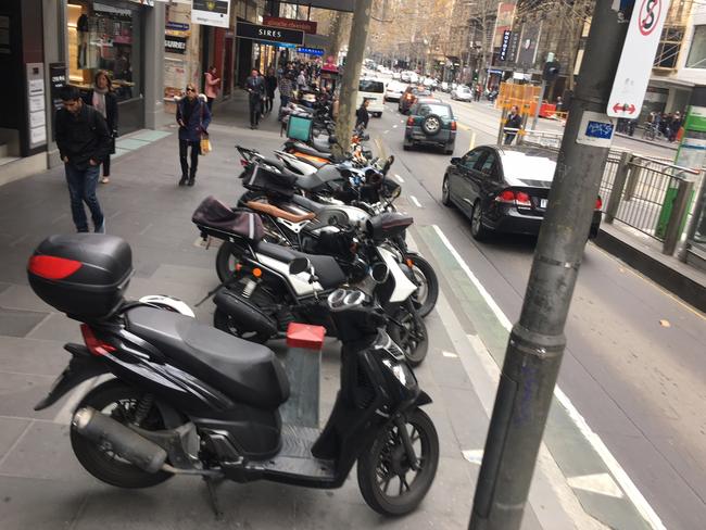 Motorcycles parked on footpaths in Melbourne's CBD.