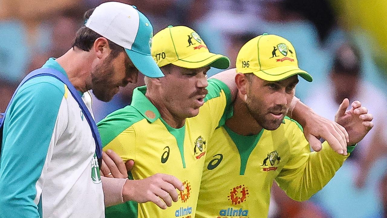 David Warner is helped off the field by teammate Glenn Maxwell after injuring his groin during the one-day series against India. Picture: AFP