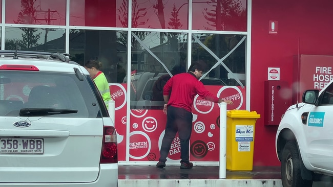 A worker tapes the windows at a Labrador service station.