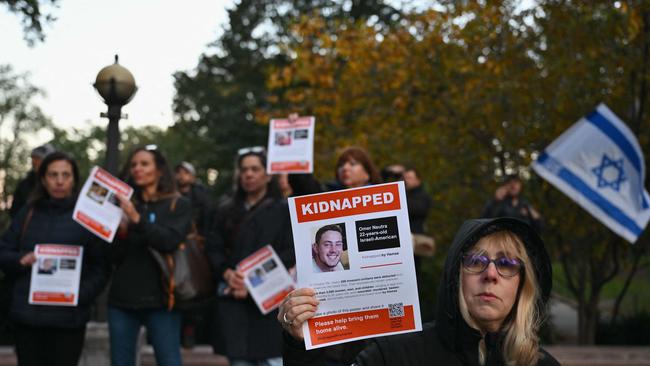 A woman holds a poster of Israeli hostage Omer Neutra during a memorial vigil for the Israeli people killed by Hamas during the October 7 attack. Picture: AFP