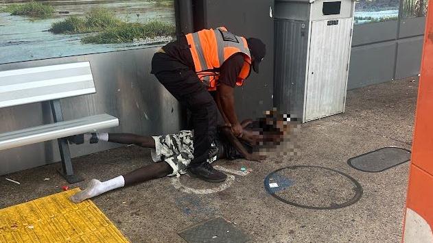 A man has been restrained by security guards outside the Cavenagh St Woolworths, Darwin, after allegedly throwing rocks at people.