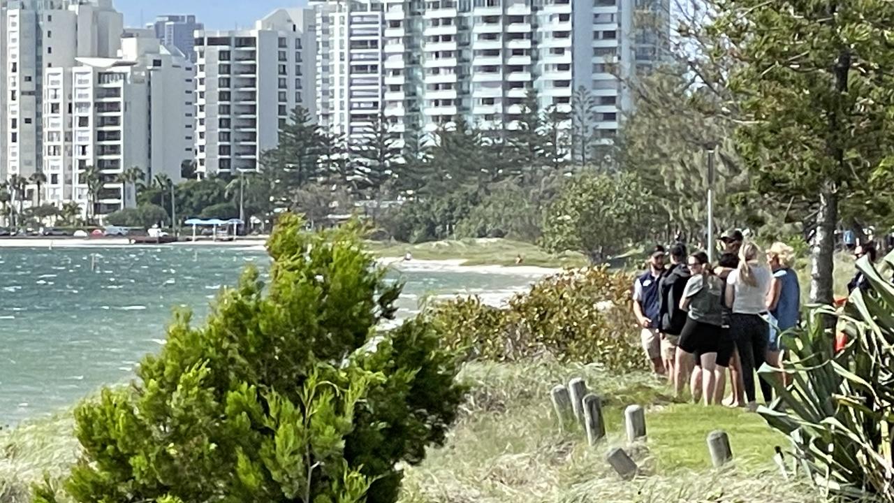 People watch on during the search for the man who went missing while swimming off Wave Break Island on Friday morning. Picture: Kyle Wisniewski