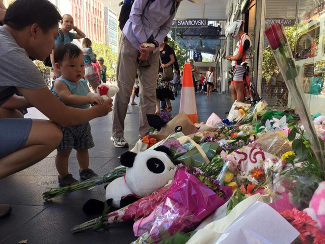 Visitors lay flowers at a floral tribute on Bourke St on Sunday. Picture: Saaed Kahn/AFP