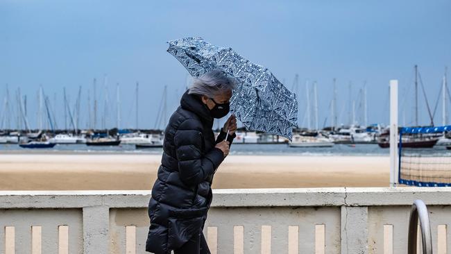 People battle a the rain and wind along Beaconsfield Pd St Kilda,  Melbourne Weather. Picture: Jason Edwards