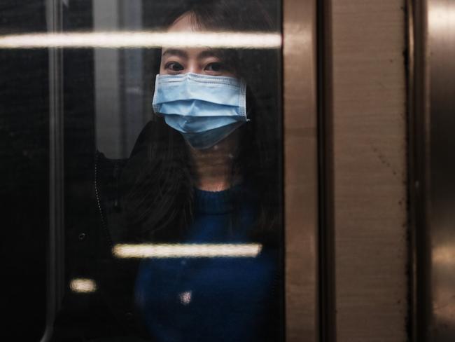 A woman wears a medical mask on the subway as New York City confronts the coronavirus outbreak. Picture: Getty