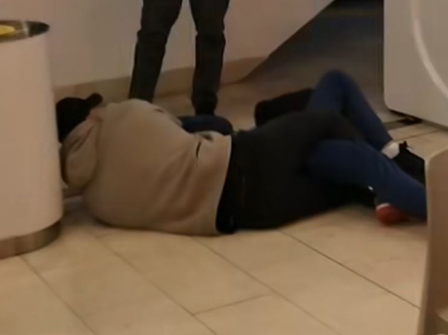A picture shows a man pinning another man to the ground.