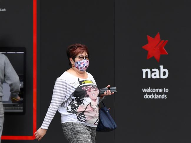 A woman walks past the headquarters of the National Australia Bank (NAB) in Melbourne November 5, 2020 after the NAB reported that its full-year after-tax profits had fallen by almost half, as the coronavirus pandemic continued to impact lenders Down Under. (Photo by William WEST / AFP)