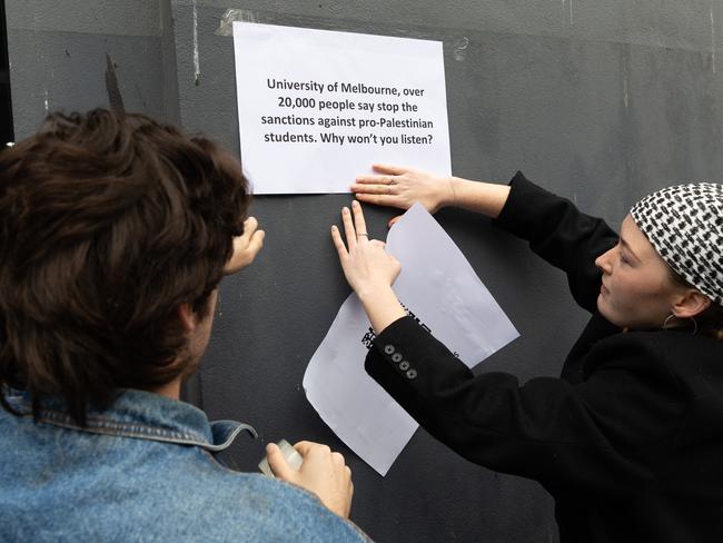 Protesters post signs about the student sanctions. Picture: Jason Edwards