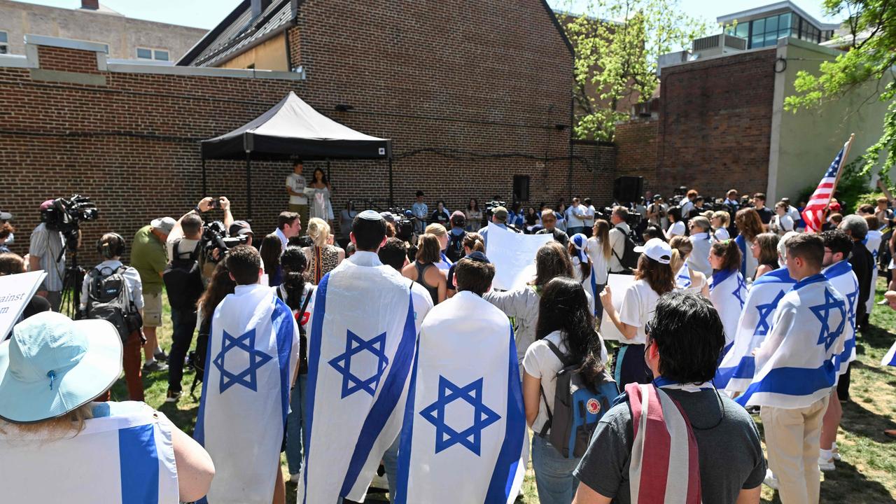 A group of attendees at a George Washington University rally against Campus Semitism wear Israeli flags in a park in Downtown Washington, DC on May 02, 2024. (Photo by ROBERTO SCHMIDT / AFP)