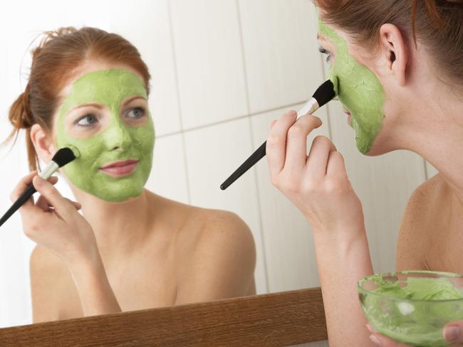 Body care series - Young woman applying green facial mask. Thinkstock