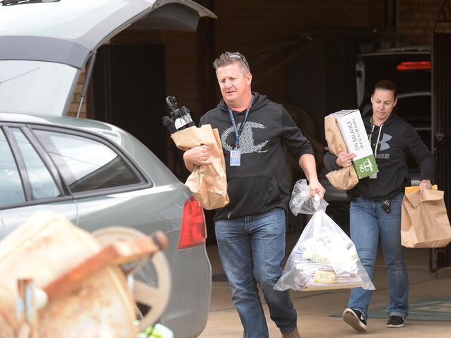 Police remove evidence from a home on Thursday after Dominic Perre was arrested.