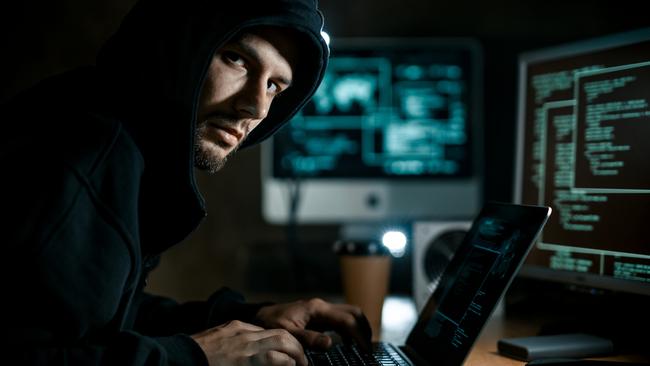 Hacker working on computer. Cyber crime concept. Scam, scammer generic.