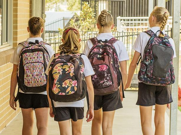 Group of junior high school girl students walking through school