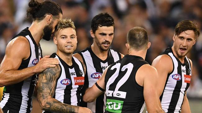 Jamie Elliott is congratulated after kicking Collingwood’s first goal against Geelong. 