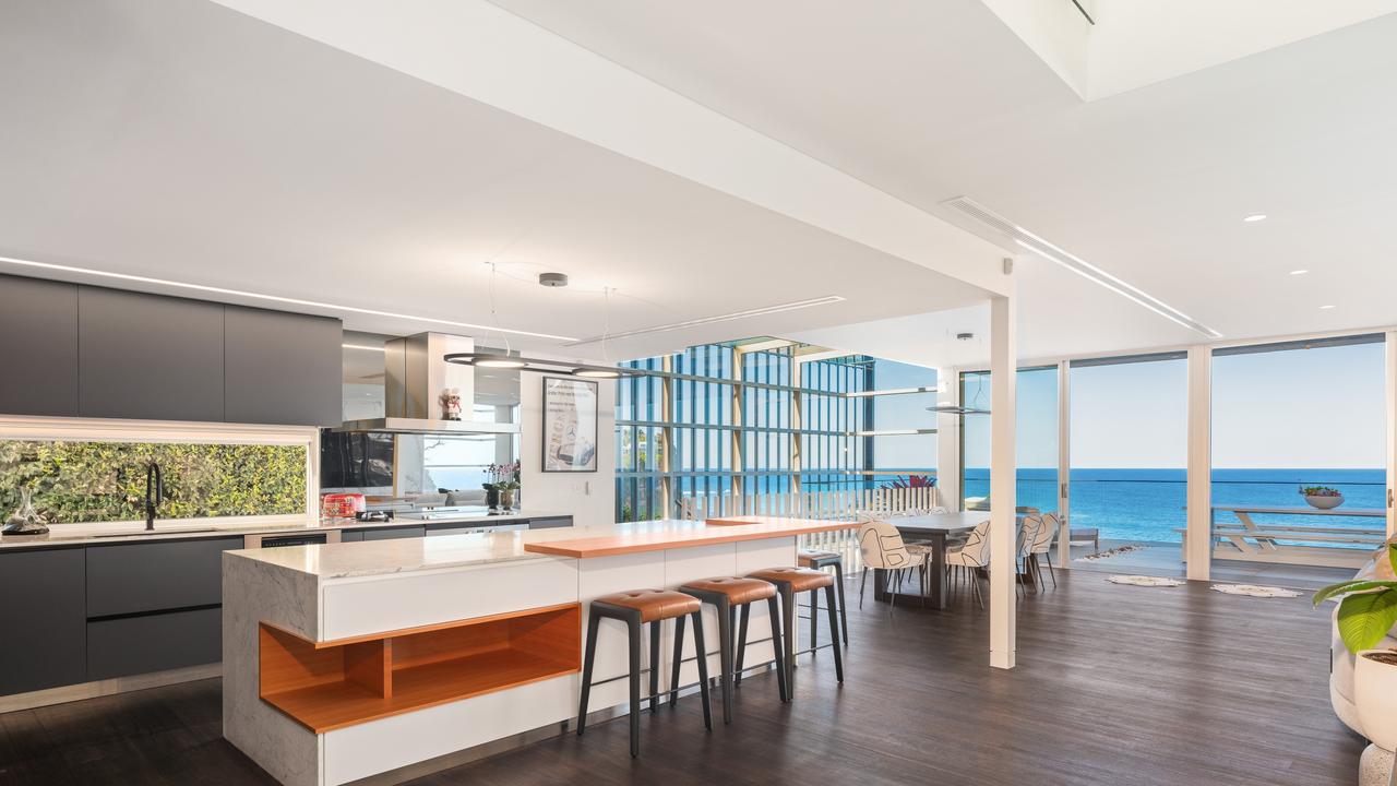 The kitchen has marble benchtops, induction cooktop and integrated Liebherr fridges.