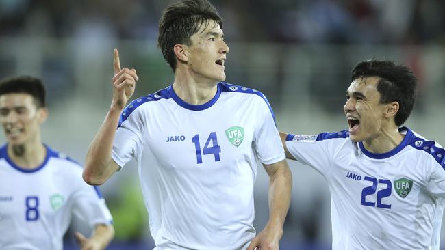 Uzbekistan's Eldor Shomurodov, centre, celebrates after scoring his side's opening goal during the AFC Asian Cup group F soccer match between Japan and Uzbekistan at Khalifa bin Zayed Stadium in Al Ain, United Arab Emirates, Thursday, Jan. 17, 2019. (AP Photo/Kamran Jebreili)