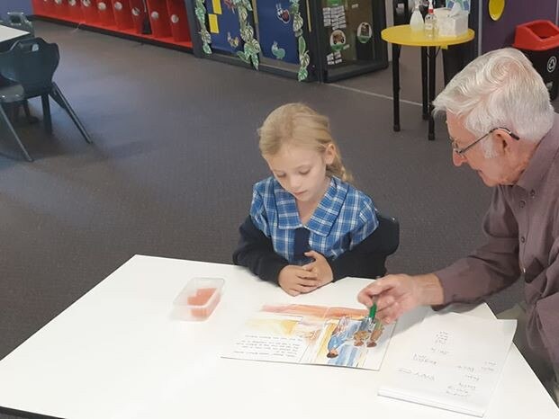 Former mayor Charlie Cox reading with children at St Mary's Primary School in Casino.