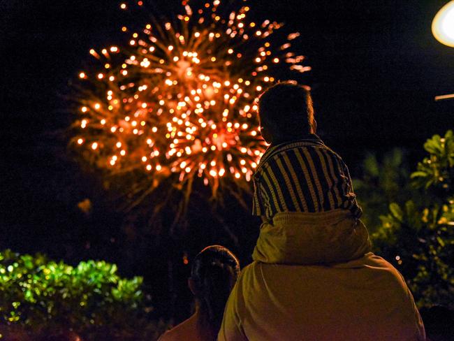 A young fella catches Darwin's New Year's Eve 2024 fireworks show on dad's shoulders at the Waterfront Precinct. Picture: Alex Treacy