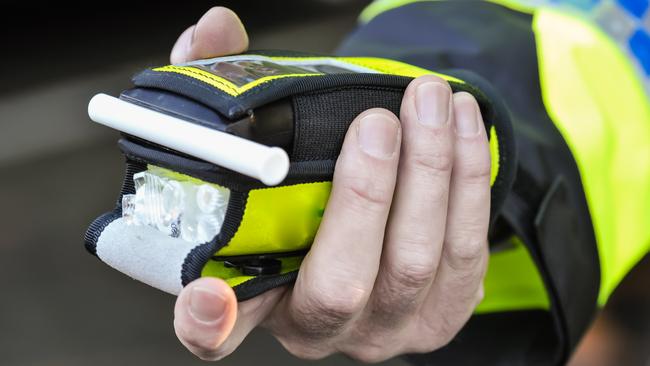 Belfast, Northern Ireland. 24 Nov 2016 - A police officer holds a roadside breathalyser alcohol breath test after taking a sample from a driver.