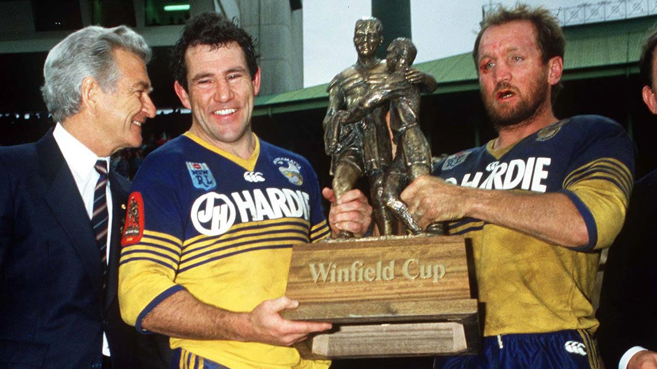 Eels legends Mick Cronin and Ray Price holding the Winfield Cup trophy after Parramatta’s win against the Bulldogs in 1986. Picure: Action Photographics