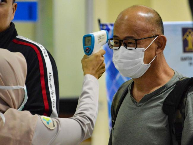 A man having his temperature checked at the Sultan Iskandar Muda International Airport. Picture: Chaideer Mahyuddin/AFP