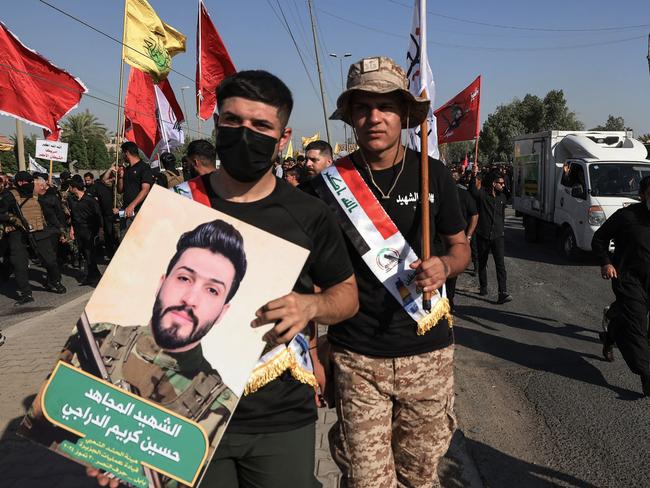 Supporters of Iraq's Hashed al-Shaabi carry a picture of one of four members of the Hashed killed in a US air strike south of Baghdad on July 31. Picture: AFP