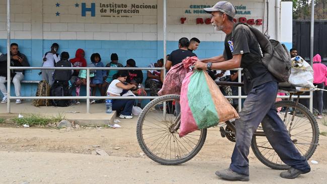 A farmer looks at Haitian and Cuban migrants en route to the United States. Picture: Orlando Sierra/AFP