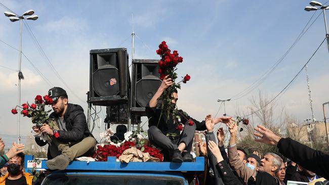 Iranians distribute red roses as people celebrate a Gaza ceasefire deal during a rally after the Friday noon prayers in Tehran. Picture: AFP