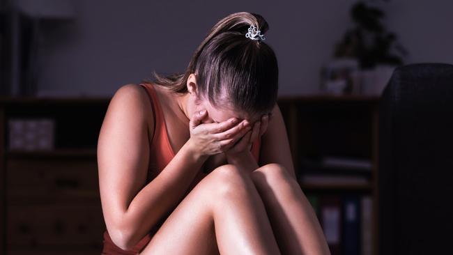 Victim of sexual harassment, domestic violence or abuse. Young sad woman crying and sitting on the floor at home. Ashamed, scared or lonely lady suffering emotional pain. Stress, trauma or sorrow. istock image