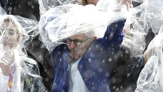 Malcolm Turnbull caugh in the rain and gladly accepted the free poncho.