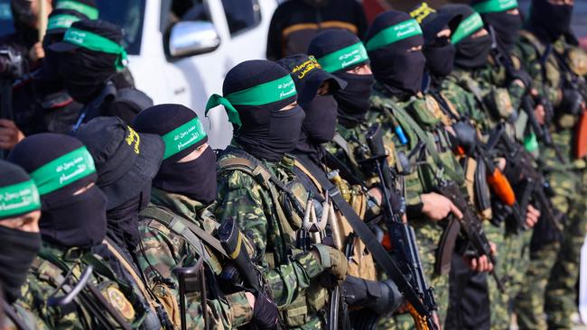 Hamas fighters secure an area in a square before releasing the four Israeli hostages to a Red Cross team in Gaza City on Saturday. Picture: AFP