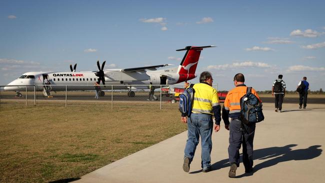 Fly In Fly Out miners walk out to their waiting plane at Moranbah airport.