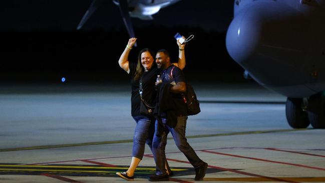 Evacuees celebrate as they arrive at Brisbane Airport. Picture: NewsWire / David Clark