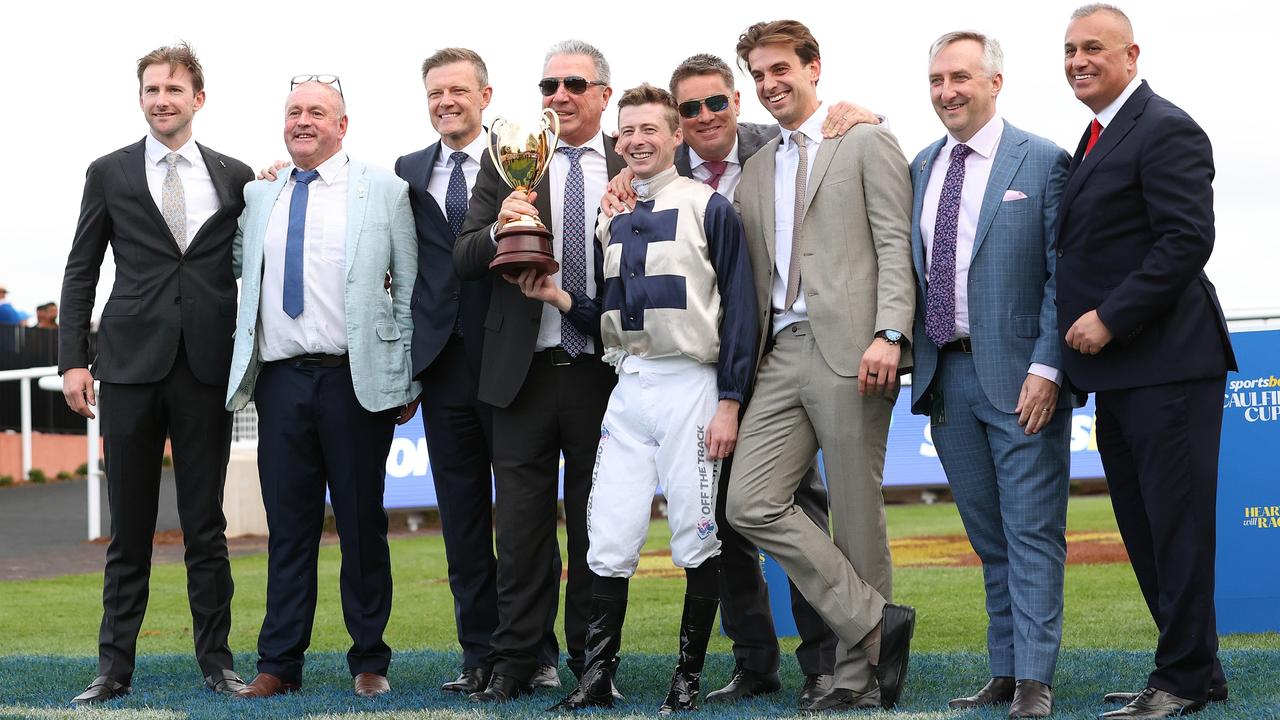 Duke De Sessa’s jockey Harry Coffey celebrates with connections after his Caulfield Cup victory. Picture: Kelly Defina / Getty Images