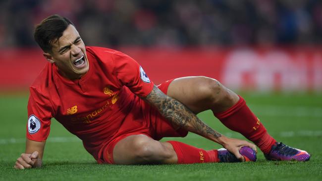 Liverpool's Brazilian midfielder Philippe Coutinho holds his foot as he lies on the pitch injured during the English Premier League football match against Sunderland.