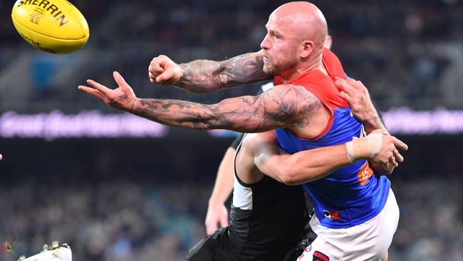 THAT’S HOW YOU DO IT: Melbourne’s Nathan Jones gets a handball away under pressure from Port Adelaide’s Sam Powell-Pepper during the round 14 clash at Adelaide Oval. Picture: David Mariuz (AAP).