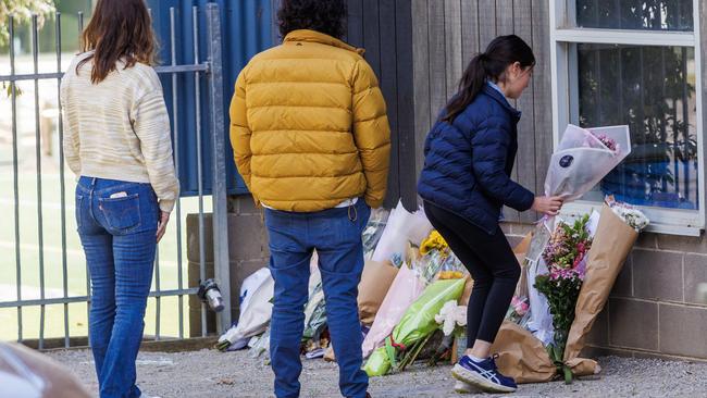 Members of the public lay floral tributes outside Auburn South Primary School on Wednesday. Picture: NewsWire / Aaron Francis